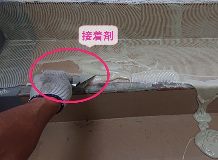 明石市のステップシート貼りで接着剤を塗っている様子
