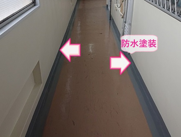 明石市の長尺シート貼りで共用廊下の両サイドにも防水塗装をしている様子