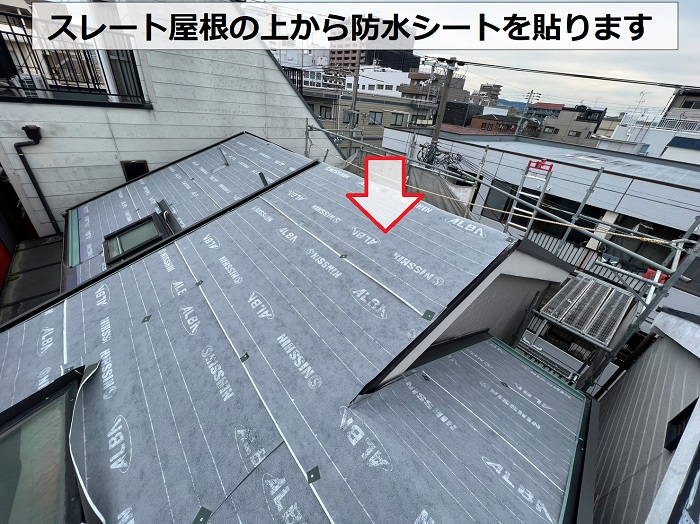 尼崎市で天窓付きのスレート屋根へ防水シートを貼っている様子