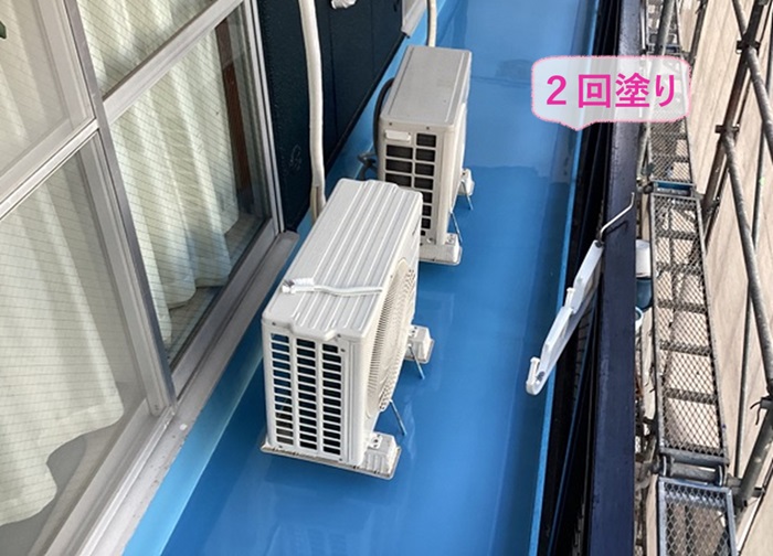 ベランダ床の防水工事で液体防水ウレタンを２回塗りしている様子