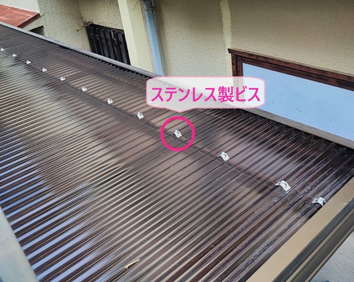 テラス屋根の透明板の貼り替えでポリカ波板をステンレス製ビスで固定している様子