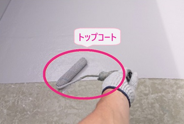 高耐久なベランダFRP防水の改修工事でトップコートを塗っている様子