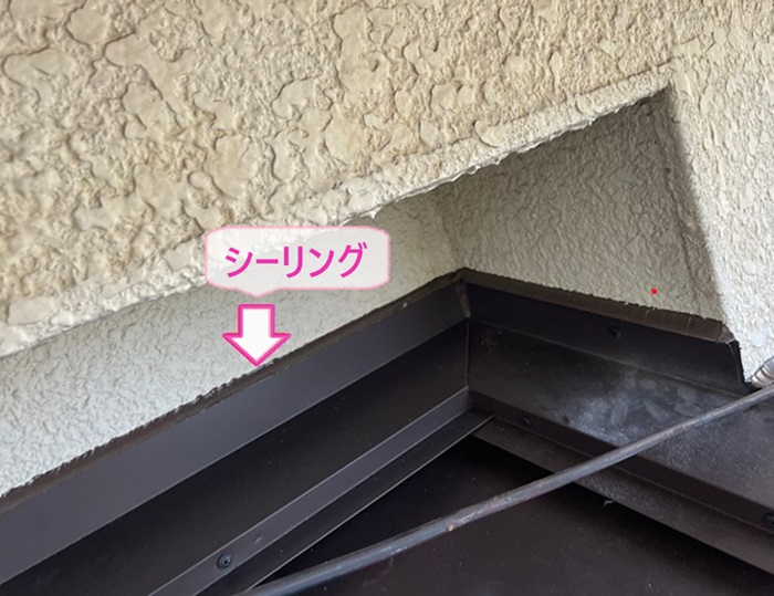 玄関屋根の改修で屋根と外壁の取り合いにシーリングを打っている様子