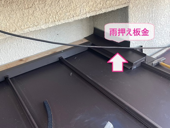 玄関屋根の改修で壁際に雨押え板金を取り付けている様子