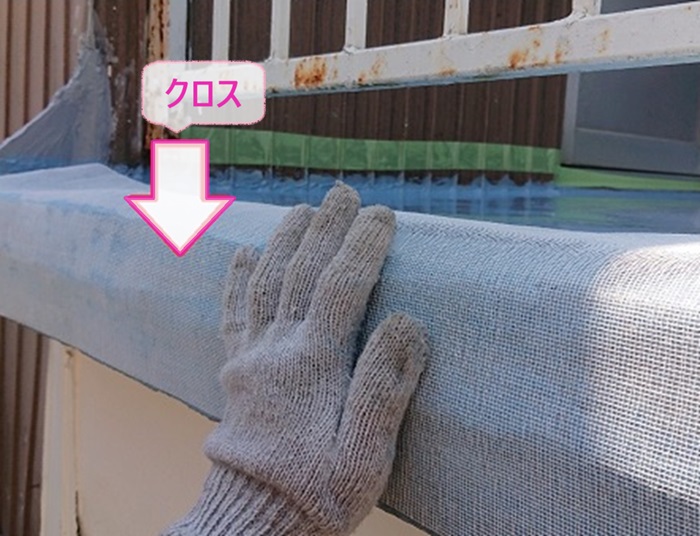 雨漏り補修をする防水工事でバルコニーのひび割れしやすい鼻先部分にはクロスを貼っている様子