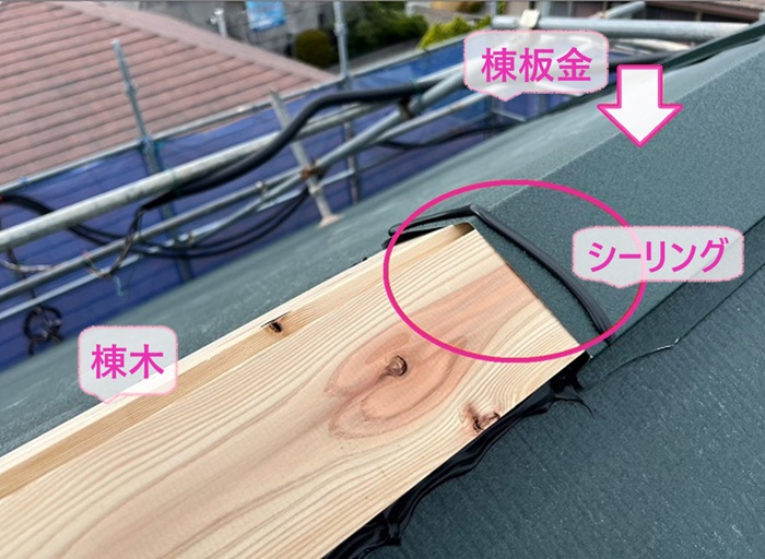 ソーラーパネル付きスレート屋根の重ね葺きで棟木と棟板金を取り付けている様子