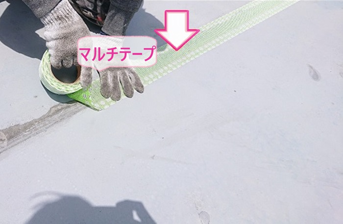 屋上塩ビシート防水の改修工事でジョイントにマルチテープを貼っている様子