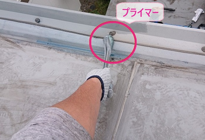 屋上塩ビシート防水の改修工事でプライマーを塗っている様子