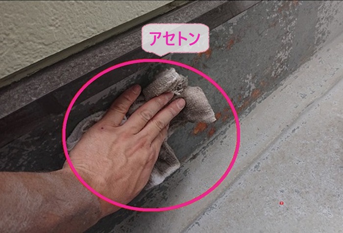 高砂市の塗膜の剝がれたFRP防水のメンテナンスでケレン作業で出た粉塵をアセトンでふき取ってる様子