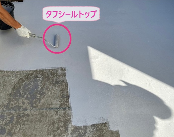 ベランダFRP防水工事の仕上げにタフシールトップを塗っている様子