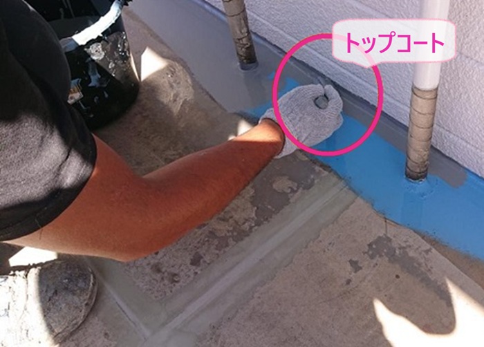 集合住宅の長尺シート貼りで共用廊下の溝にトップコートを塗っている様子