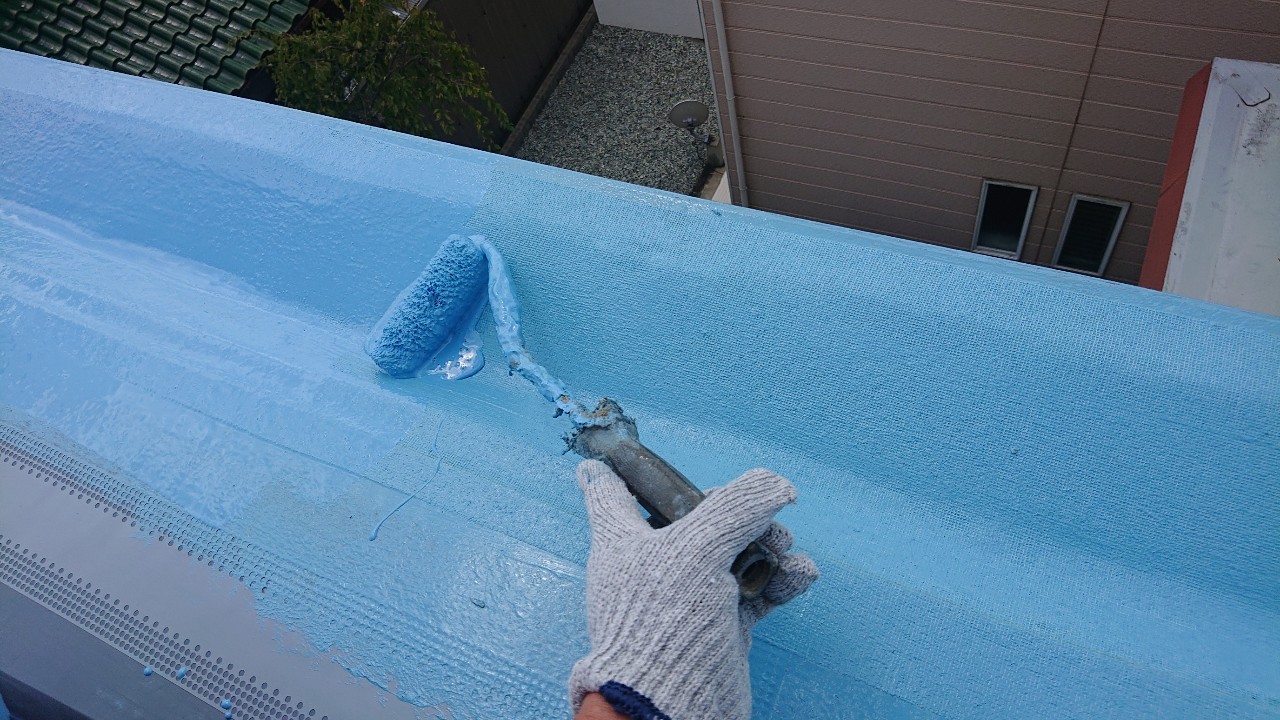 陸屋根にウレタン防水を塗っている様子