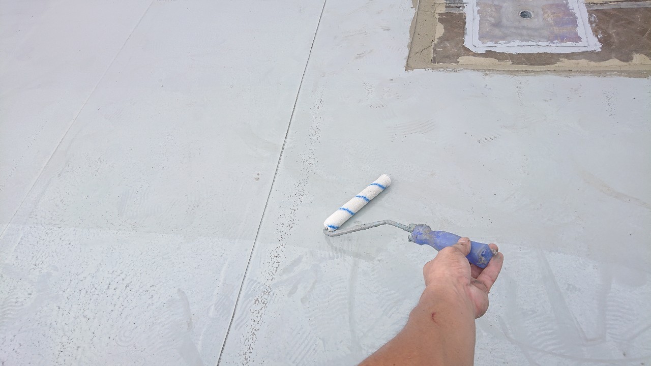 神戸市須磨区での陸屋根防水工事で下塗りを行っている様子