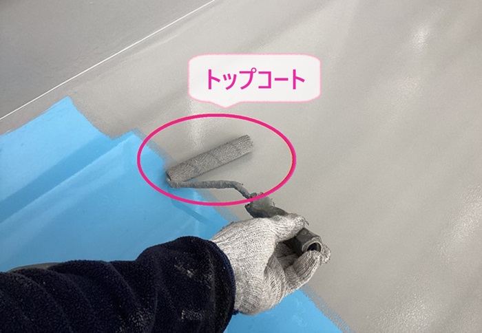 集合住宅のベランダ防水工事でトップコートを塗っている様子