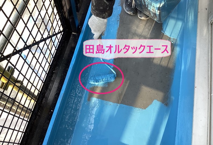 集合住宅のベランダ防水工事の中塗りで田島オルタックエースを使用している様子