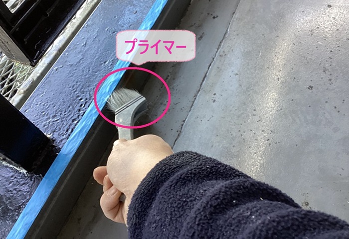 集合住宅のベランダ防水工事でプライマーを塗っている様子