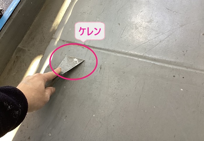 集合住宅のベランダ防水工事でケレンしている様子