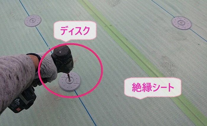 屋上のゴムシート防水貼り替えで絶縁シートを貼ってディスクを取り付けている様子