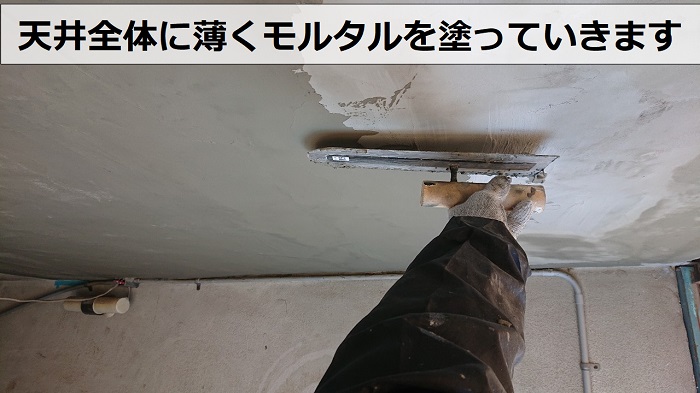 神戸市長田区の天井修理で仕上げのセメントを塗っている様子