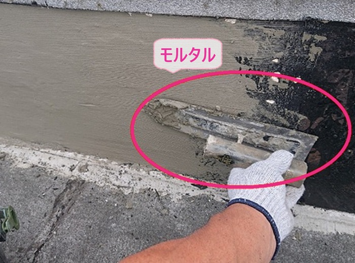 屋上リニューアル工事で立ち上がり部分をモルタルで補修している様子