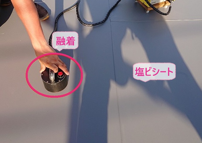 屋上リニューアル工事で塩ビ防水シートを貼って専用の機械で融着している様子