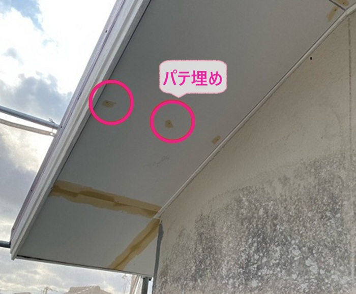 軒裏の修繕工事でケイカル板をビス固定してビス頭をパテ埋めしている様子