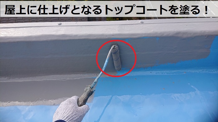 屋上防水リフォーム工事でトップコートを塗っている様子