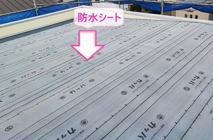 緩傾斜なガルバリウム鋼板屋根材の雨漏り修理で新しい防水シートを貼っている様子