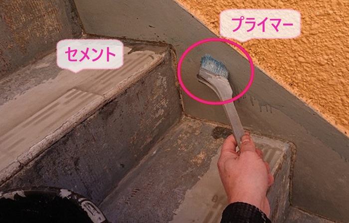 3階建てマンションの階段補修工事でセメントで補修してサイドにプライマーを塗っている様子