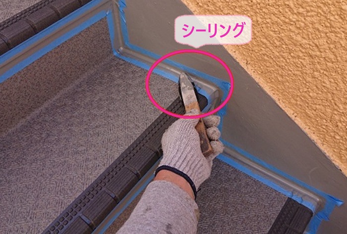 3階建てマンションの階段補修でシーリングを打って仕上げている様子