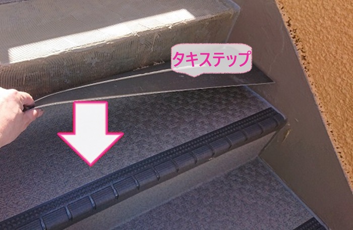 3階建てマンションの階段補修でタキステップを接着剤で貼っている様子