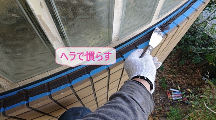 神戸市須磨区の雨漏りしている外壁タイルでシーリング材をヘラでキレイに慣らしている様子