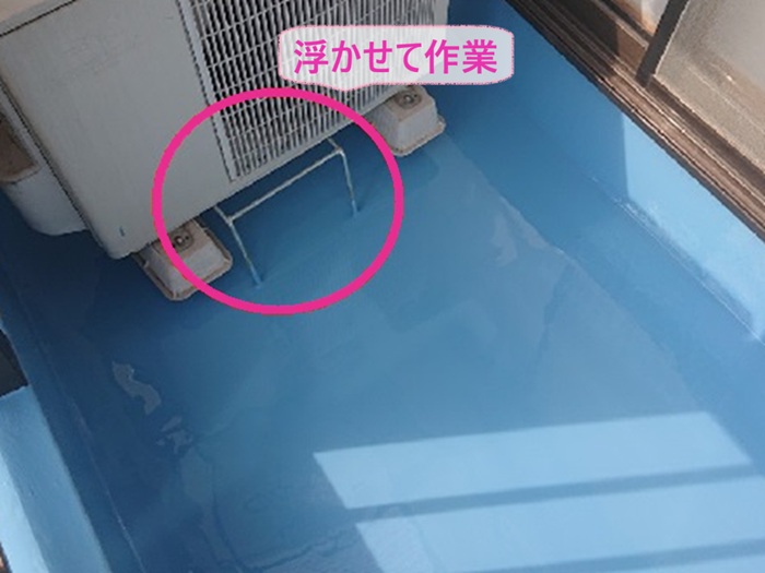 ベランダ防水改修で室外機を浮かせて作業している様子