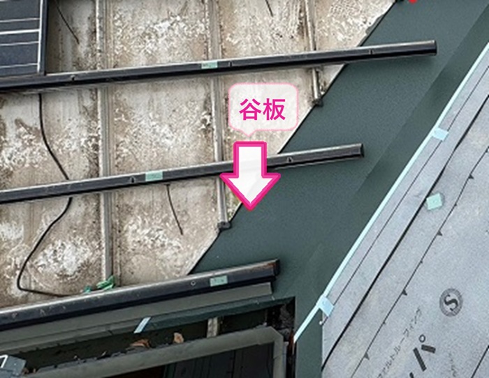 ソーラーパネル搭載屋根の改修工事で金属屋根との取り合いに谷板を取り付けている様子
