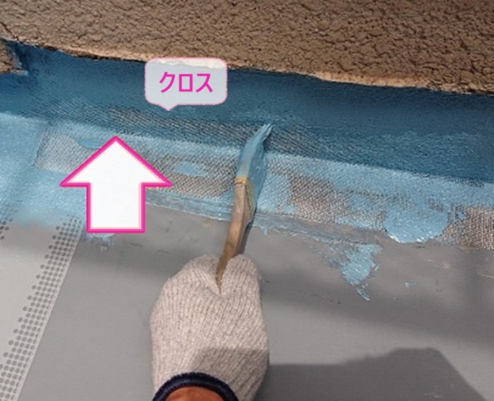 ベランダ防水改修で入隅部分にクロスを貼っている様子