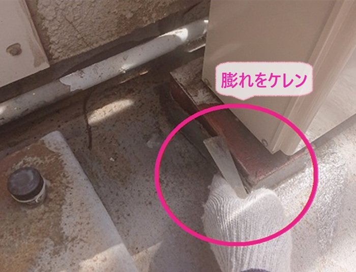 ベランダ防水改修で膨れが発生してる既存のベランダ床をケレンしている様子