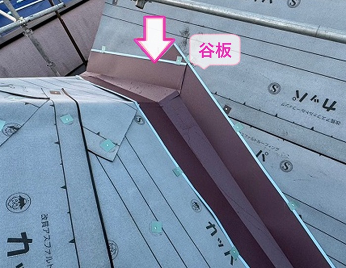 鋭角で多面なコロニアル屋根の重ね施工で谷板を取り付けている様子