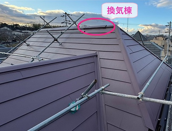 鋭角で多面なコロニアル屋根の重ね施工で換気棟を取り付けている様子