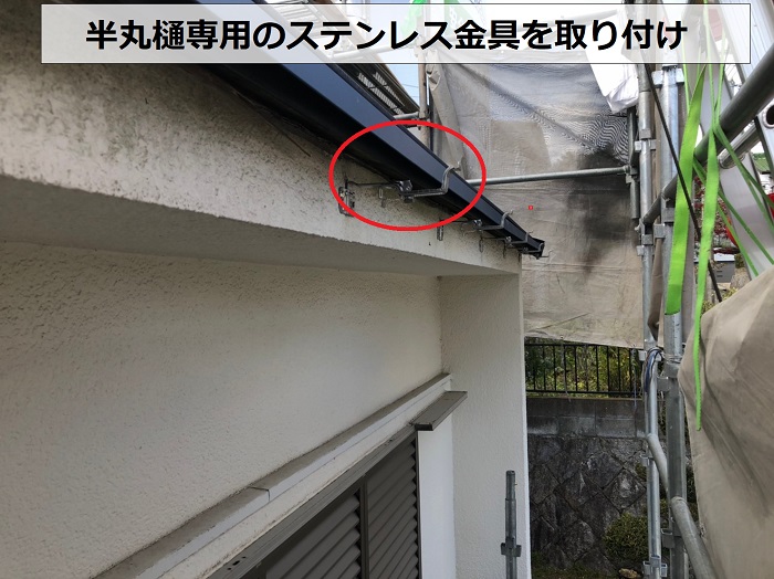 神戸市兵庫区での雨樋交換工事でステンレス製の金具を取り付けている様子