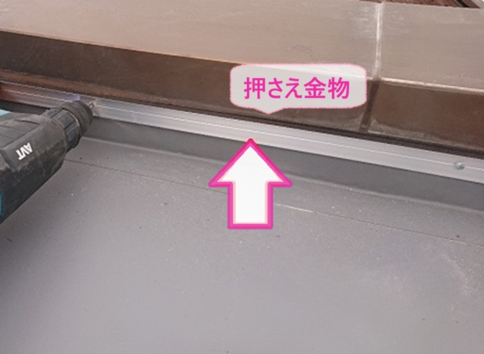 集合住宅の防水改修で立ち上がり部分に押え金物を取り付けている様子