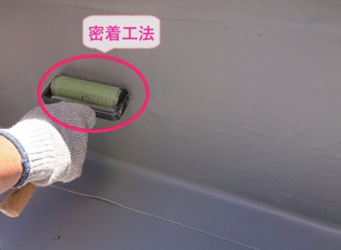 平屋根へのシート防水リフォームで立ち上がり部分には密着工法している様子