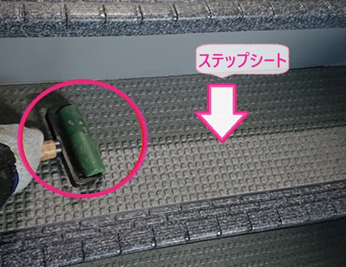 アパート共用部の床改修で新しいステップシートを貼っている様子