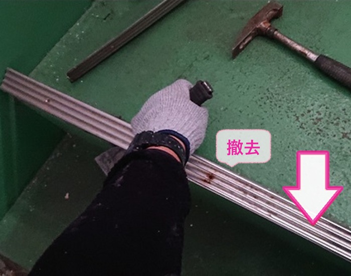 アパート共用部の床改修で既存のステップシートを撤去している様子